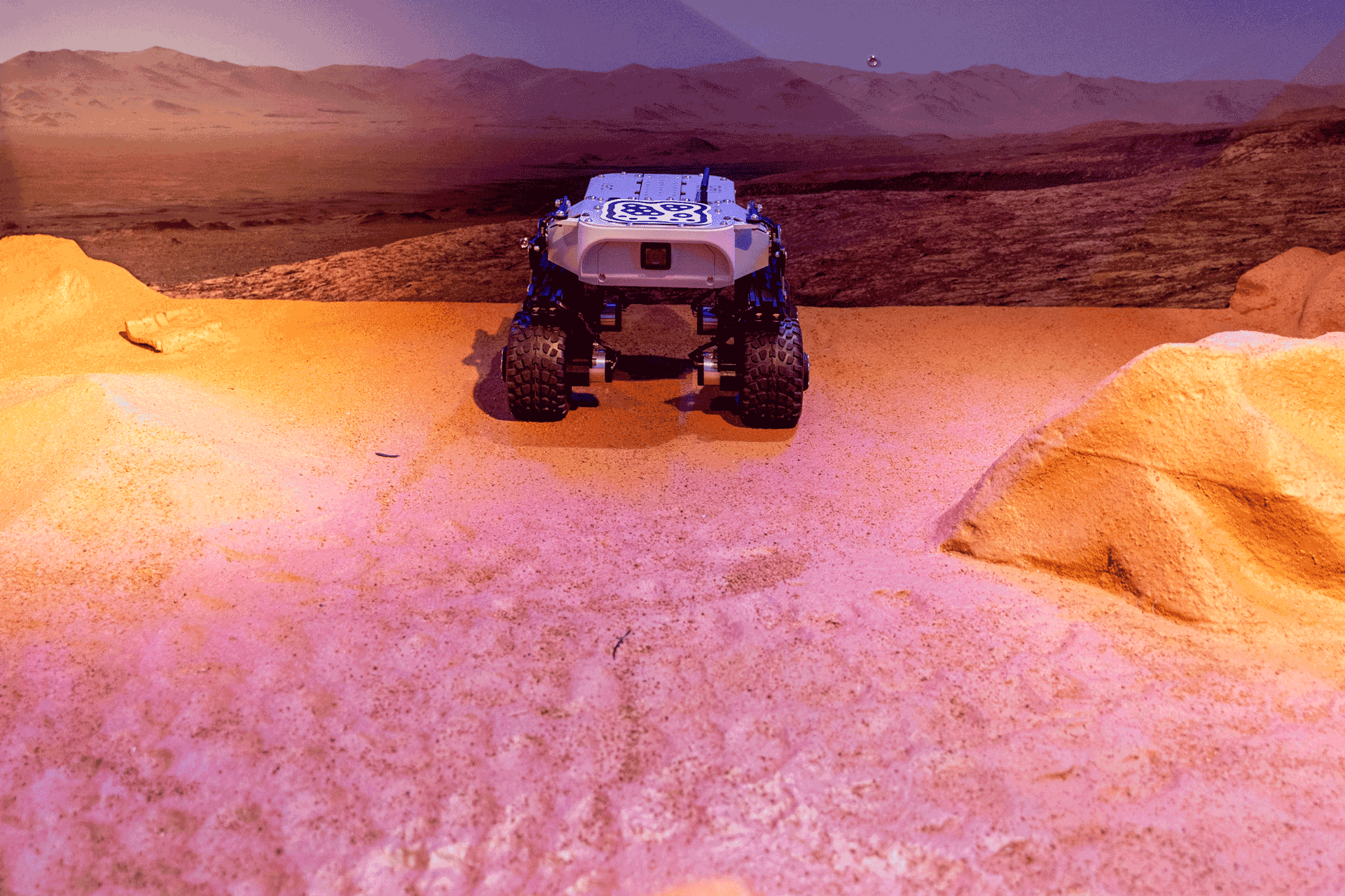 A Mars rover model stands in the Martian landscape