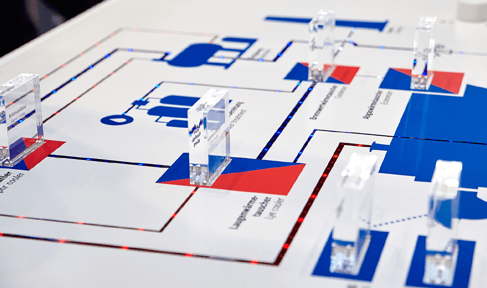Austauschbare Blöcke stehen auf einem Schaubild, das auf den Messetisch aufgebracht ist