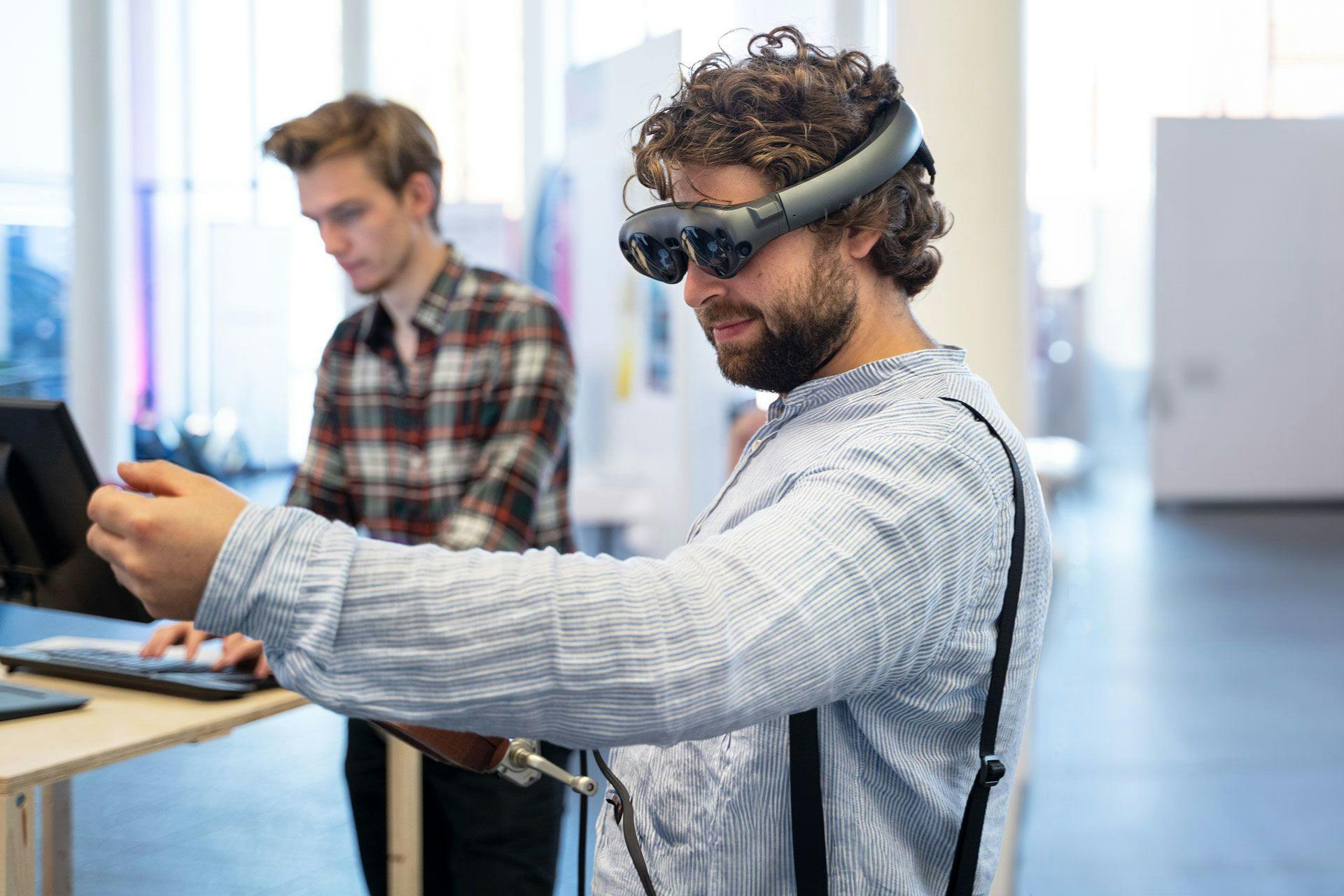 Person wearing Magic Leap goggles and holding a virtual fish